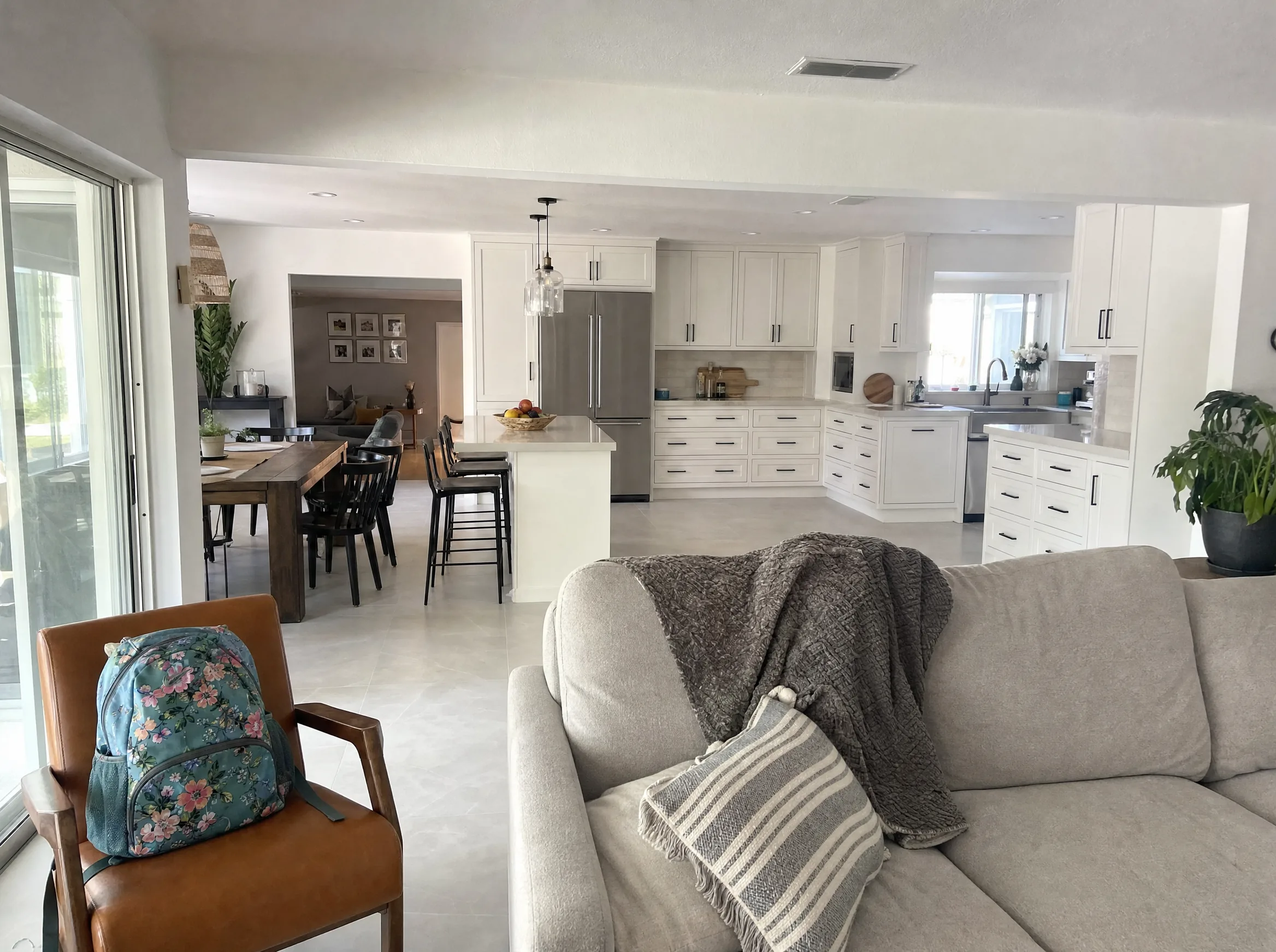 Renovated living area with an opened floor plan flowing into the kitchen and new tile flooring