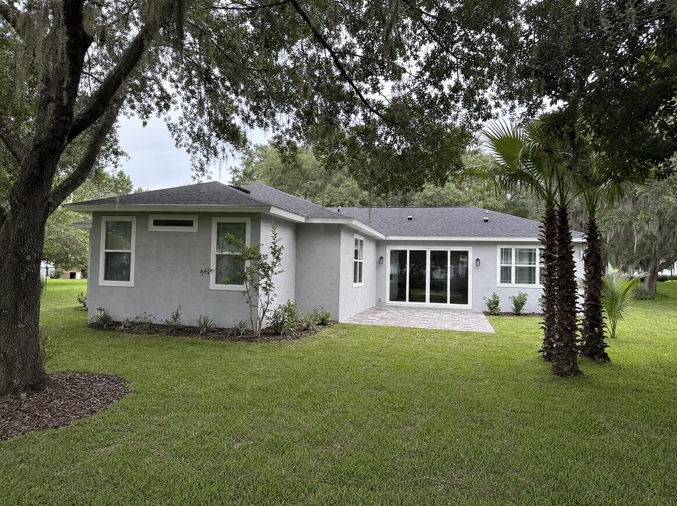 Finished room addition on a stucco Florida home matched to the existing roofline and paint