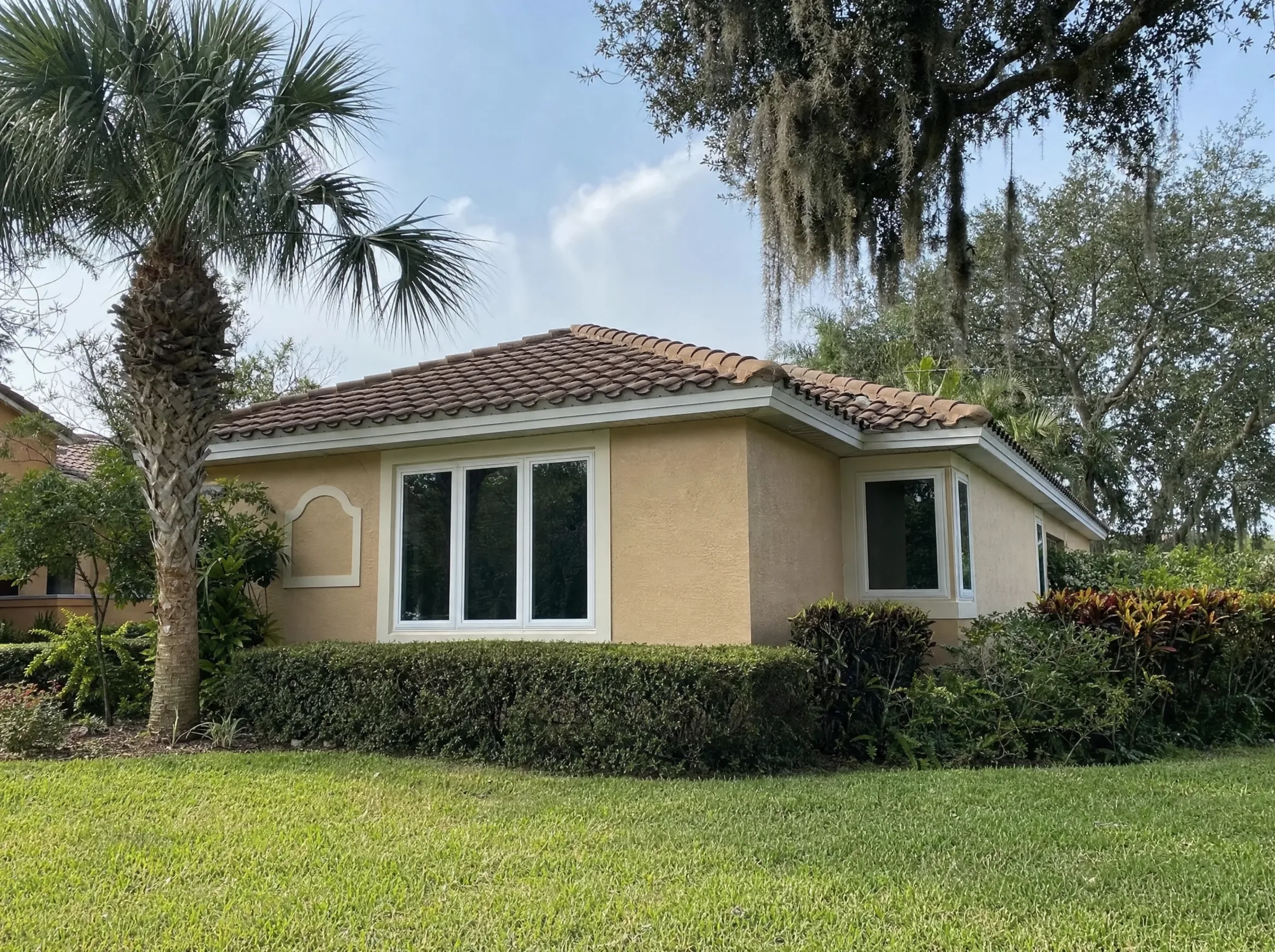 New white impact windows on a stucco Florida home with a tile roof