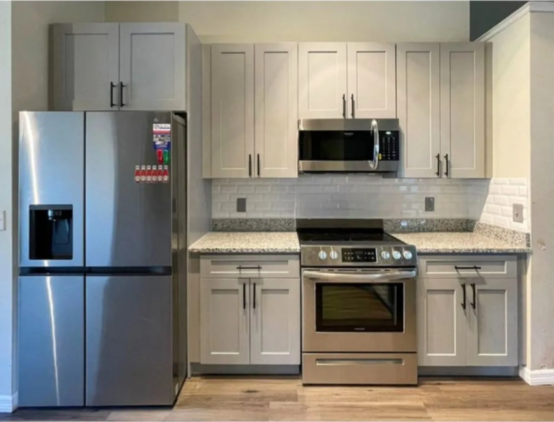 After: Kitchen after the remodel: cherry cabinets replaced with gray shaker cabinets and stainless appliances