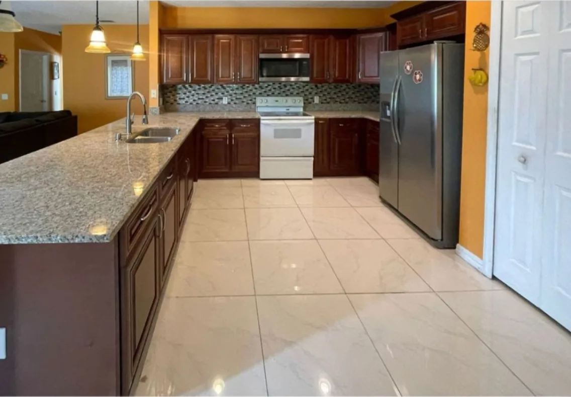 After: Kitchen after the remodel: dated kitchen replaced with cherry cabinets and granite counters