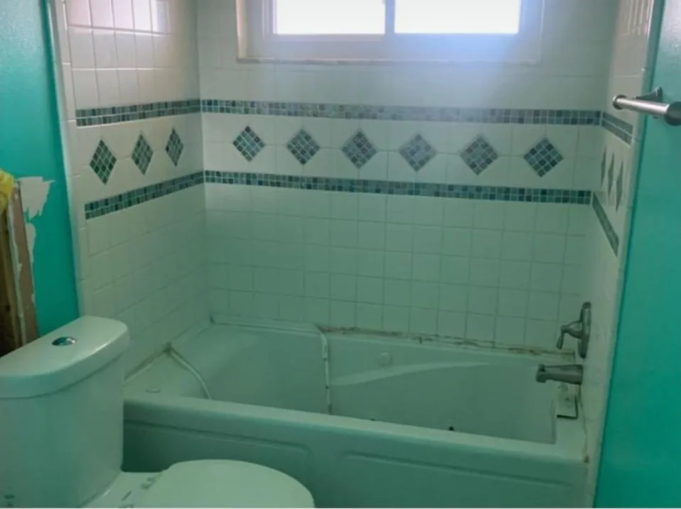Before: Bathroom before the remodel: teal tile tub and toilet