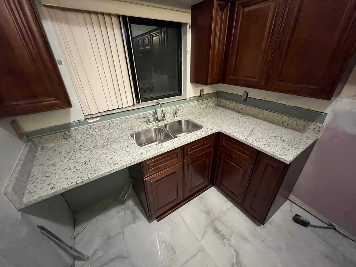L shaped white granite countertop over cherry cabinets