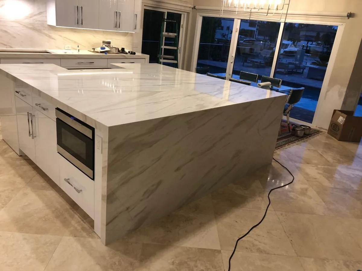 Oversized marble look waterfall island with built in microwave drawer