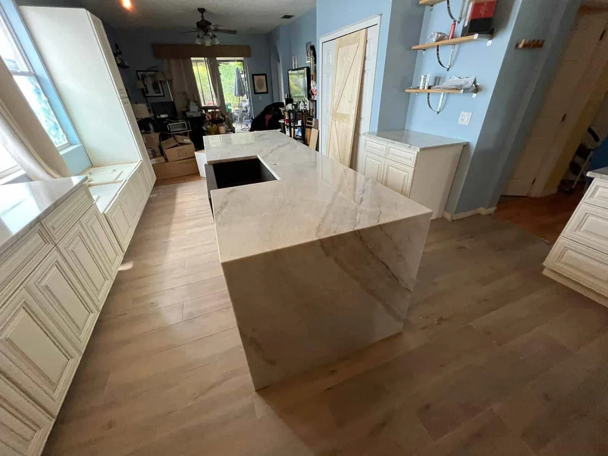Quartz waterfall island in a white raised panel kitchen