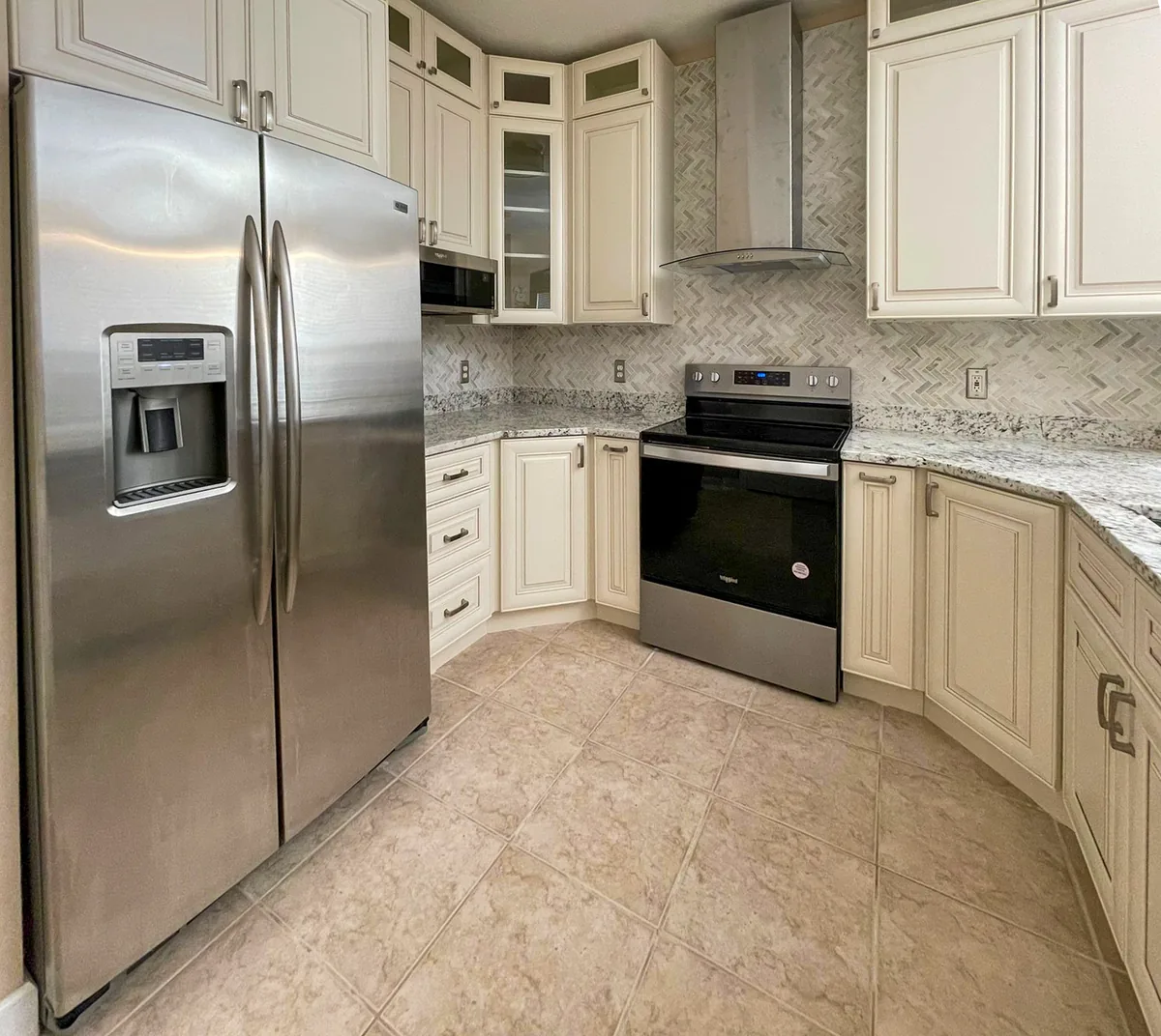 Cream raised panel kitchen with granite counters and stainless appliances