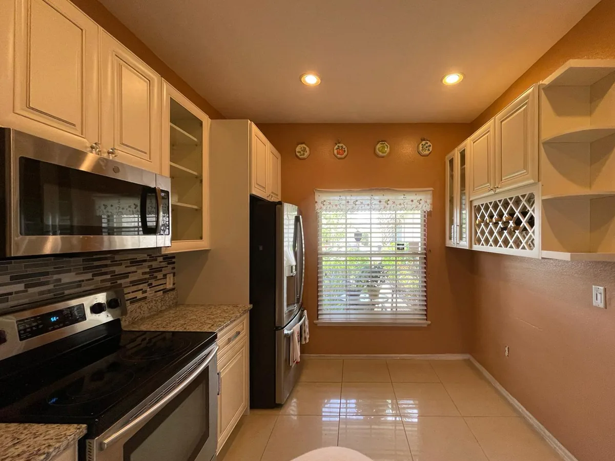 Cream cabinets with a mosaic tile backsplash and built in wine rack