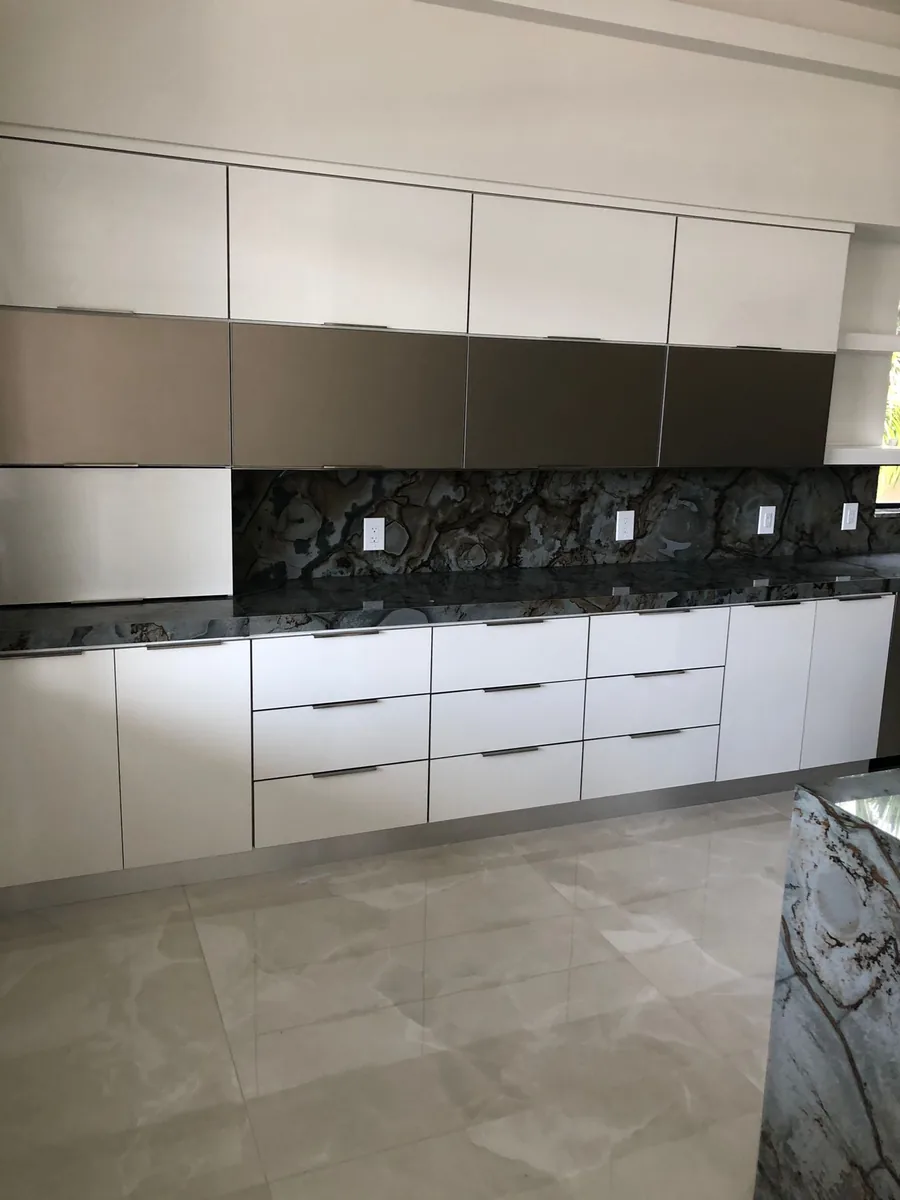 White and gray flat panel kitchen with a dark granite full height backsplash