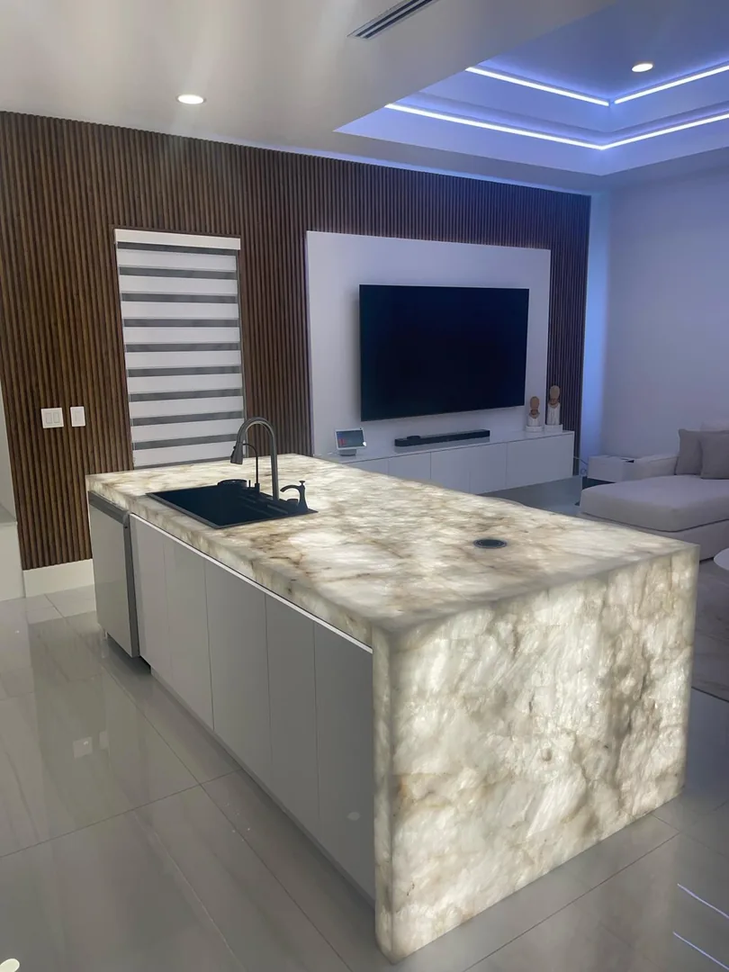 Backlit onyx island glowing in a white modern kitchen