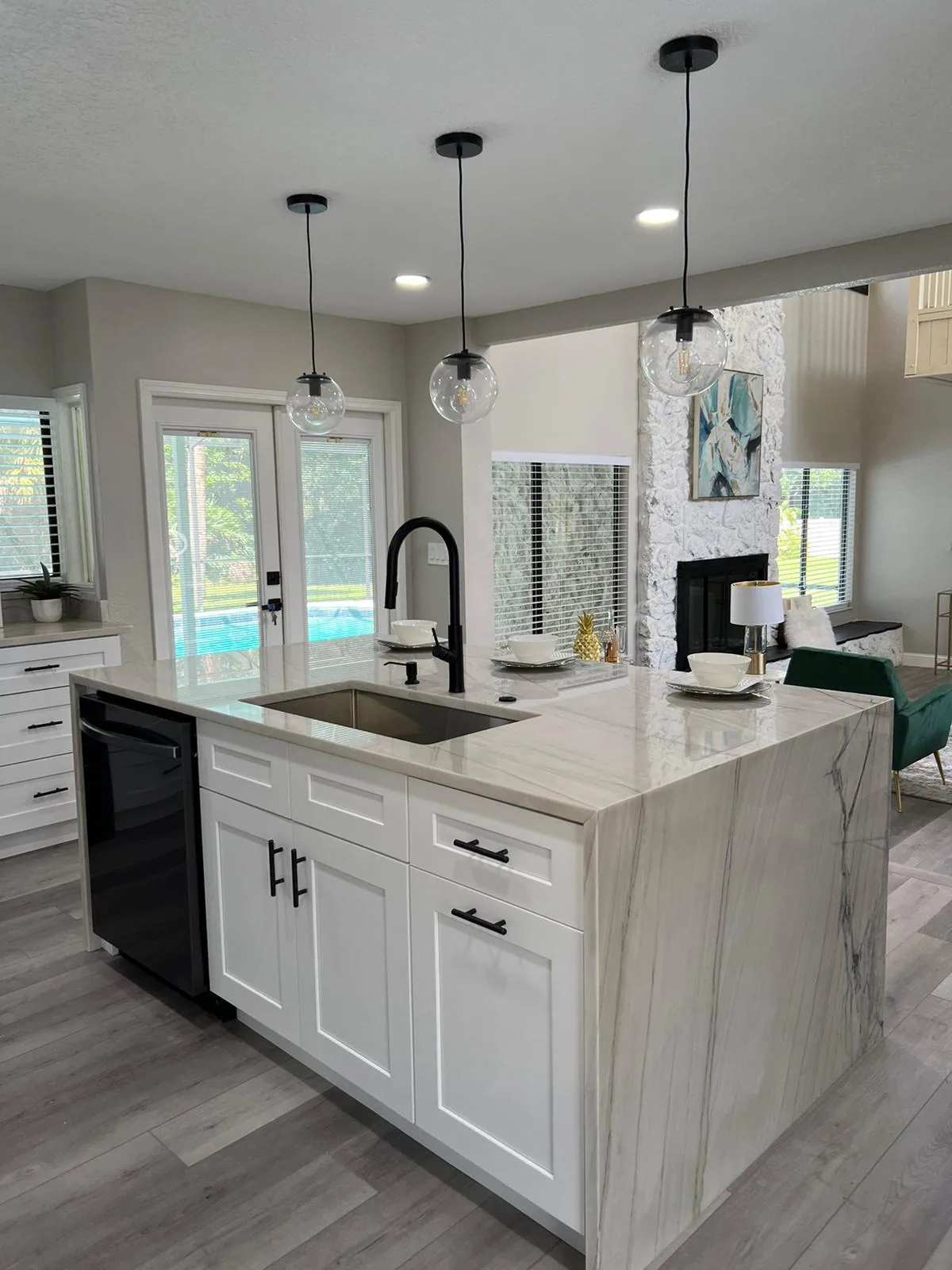 White shaker island with a quartzite waterfall end and black faucet