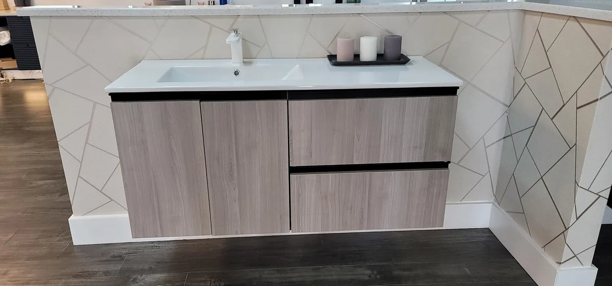 Floating wood grain vanity with a geometric tile wall