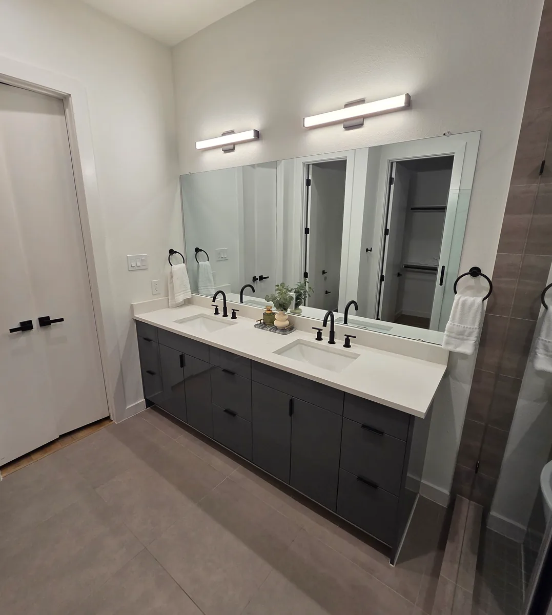Charcoal double vanity with white quartz top and backlit mirror